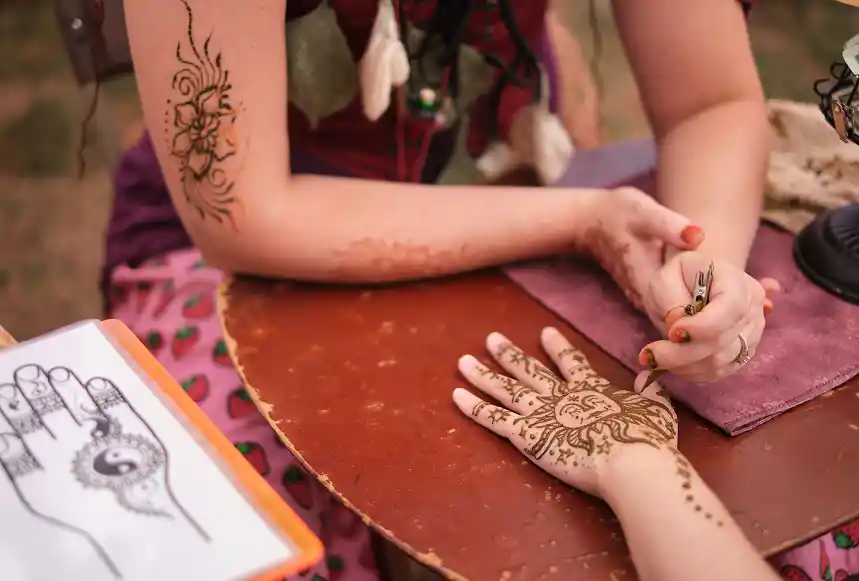 Henna artist creating intricate sun and star design